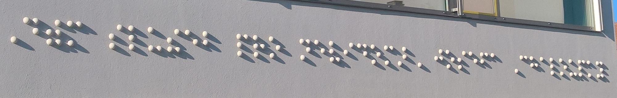 na průčelí unikátní dekorační prvek v podobě plastického nápisu v Braillově písmu.